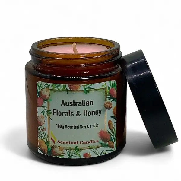 Scented candle in an amber jar with a floral label on a white background