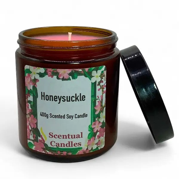 Honeysuckle scented candle in an amber jar with a floral label on a white background