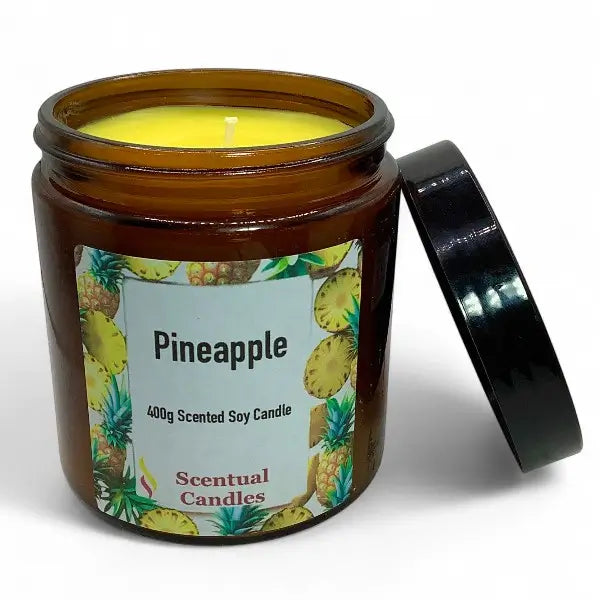 Scentual Candles pineapple scented candle in an amber jar with a black lid.