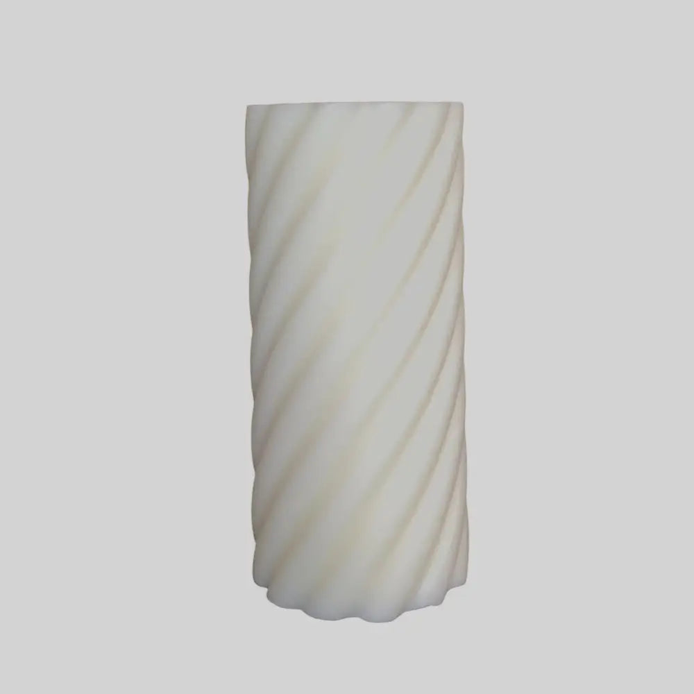 White candle with spiral pattern on a light gray background