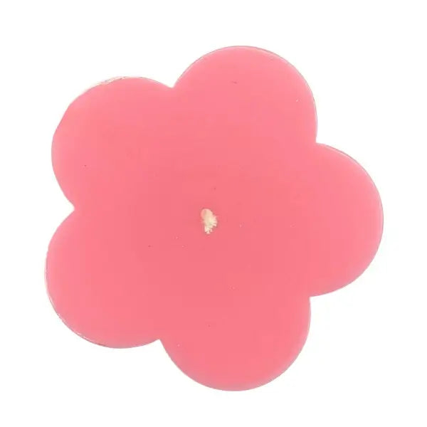 Pink flower-shaped candle on a white background