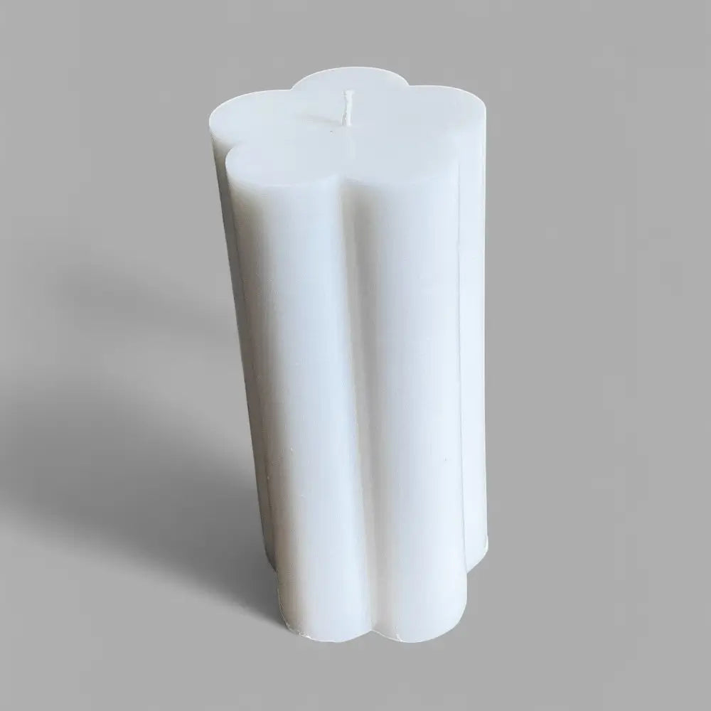 White flower-shaped candle on a gray background