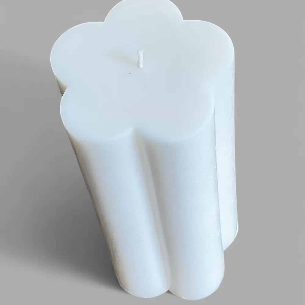 White flower-shaped candle on a gray background