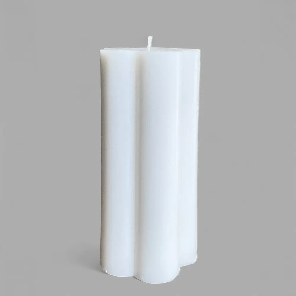 White flower-shaped candle on a gray background