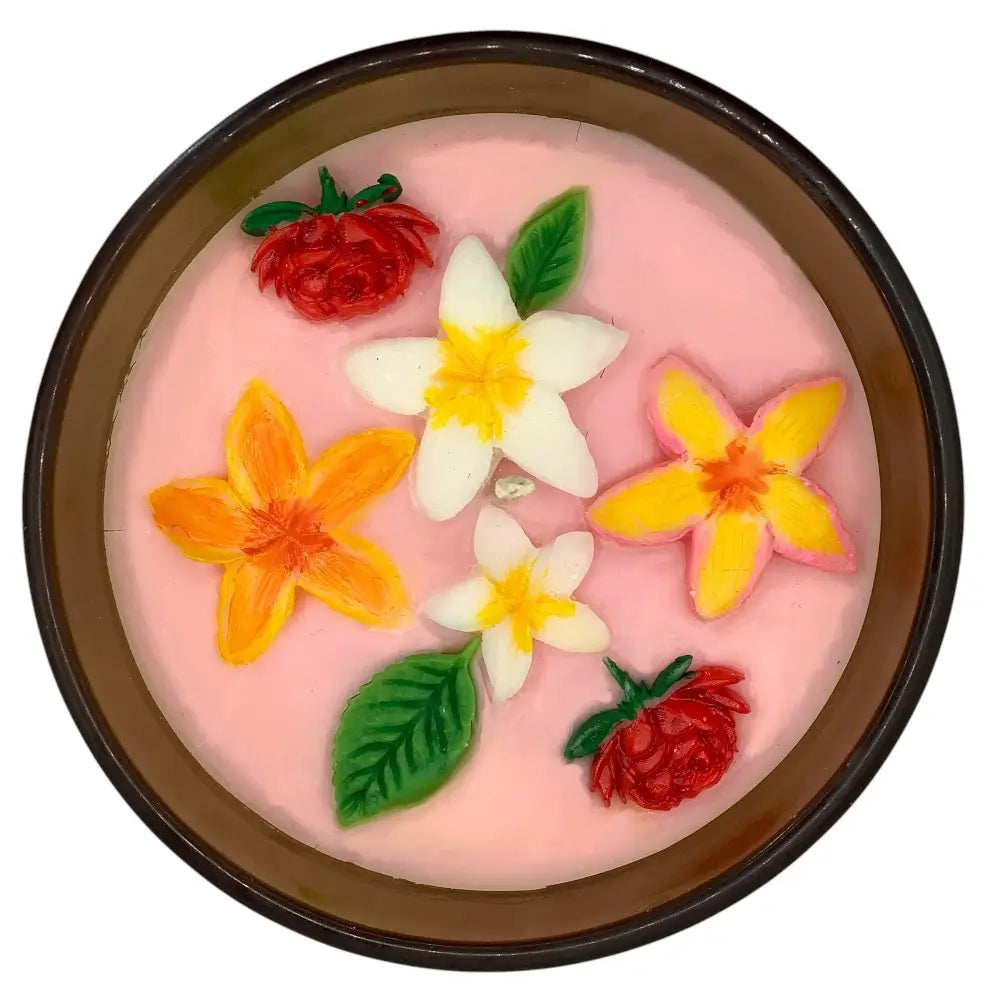 Pink candle top with floral and berry decorations in a brown jar