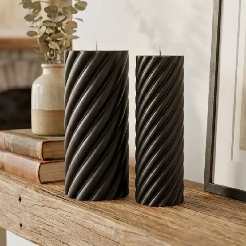 Pillar Candle Set - Two Spiral Columns with twisted black candles displayed on a wooden table.