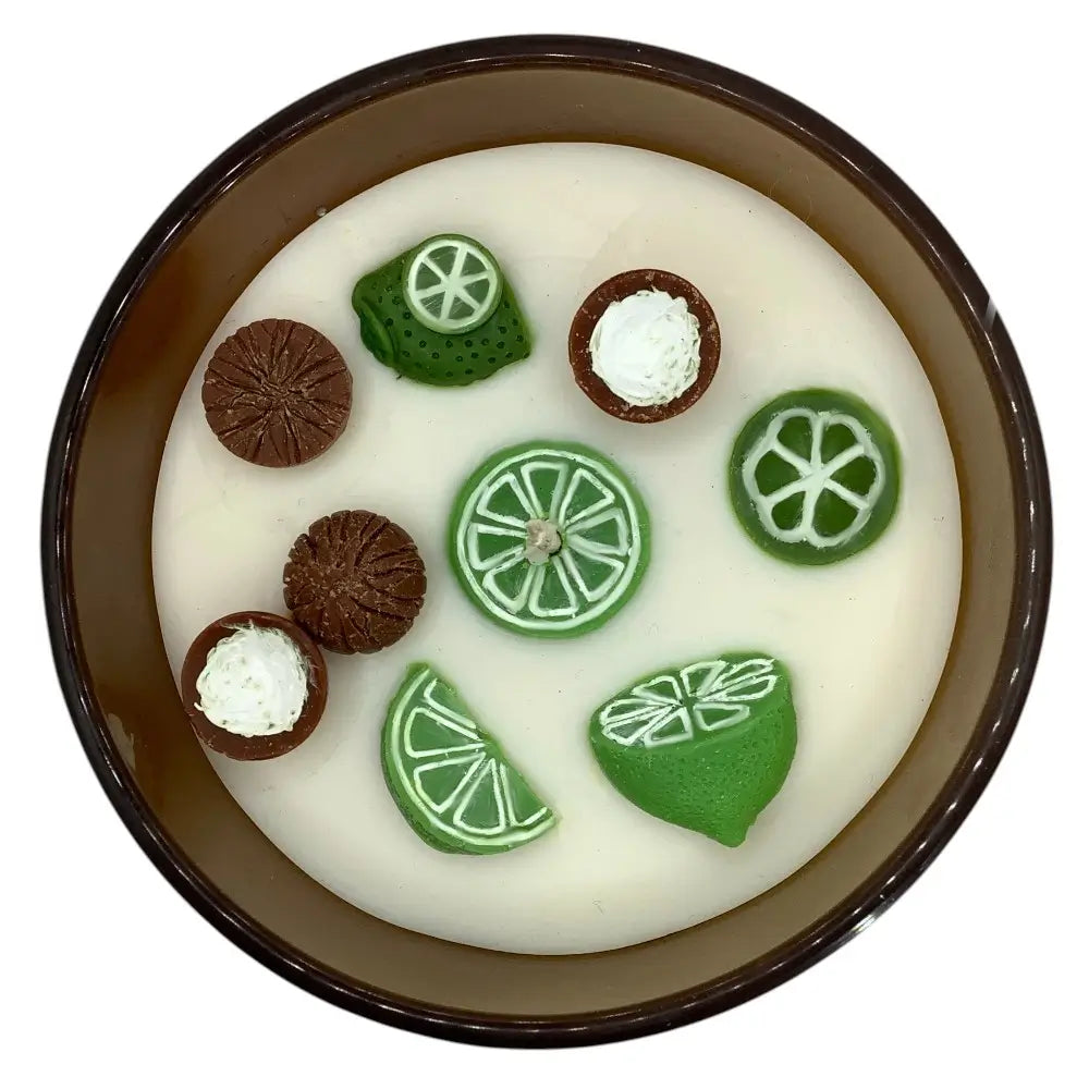 Decorative candle top with lime and coconut decorations on a white background
