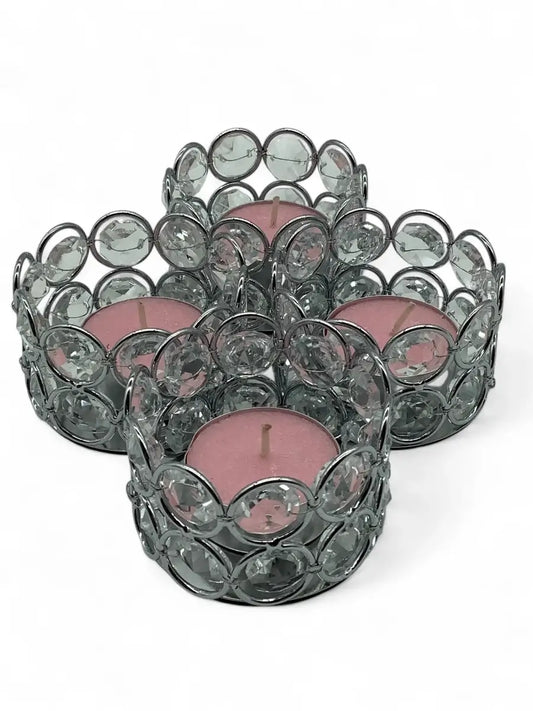 Set of crystal candle holders with pink candles on a white background