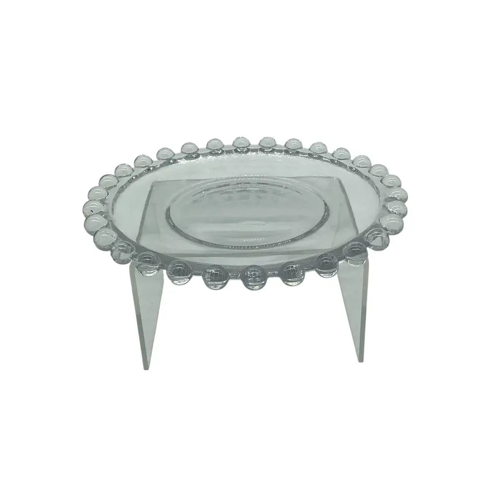 Clear glass candle plate on a stand with a white background