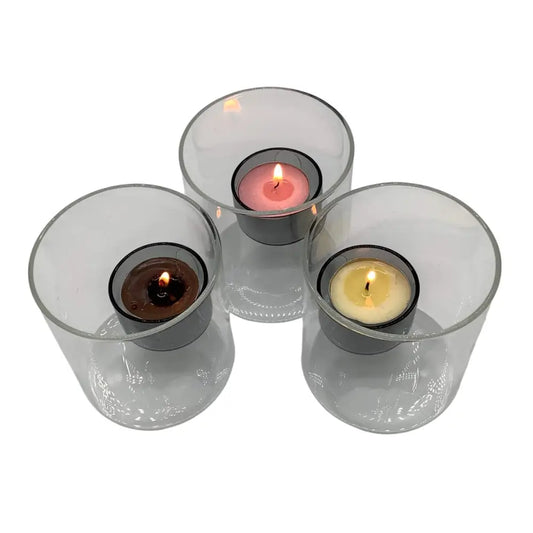 Three glass candle holders with candles on a white background