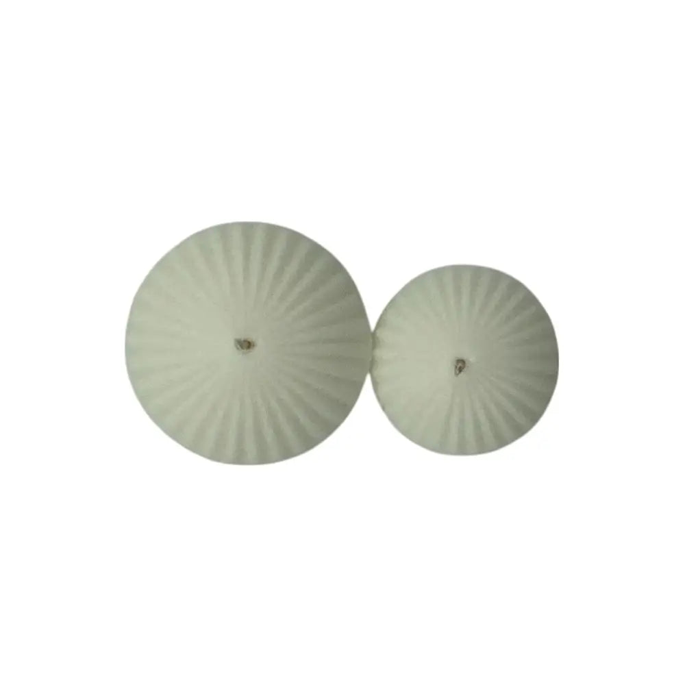 Pair of round, floating candles on a white background