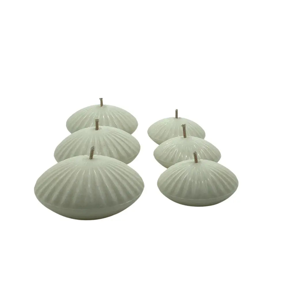Set of six light green shell-shaped candles on a white background
