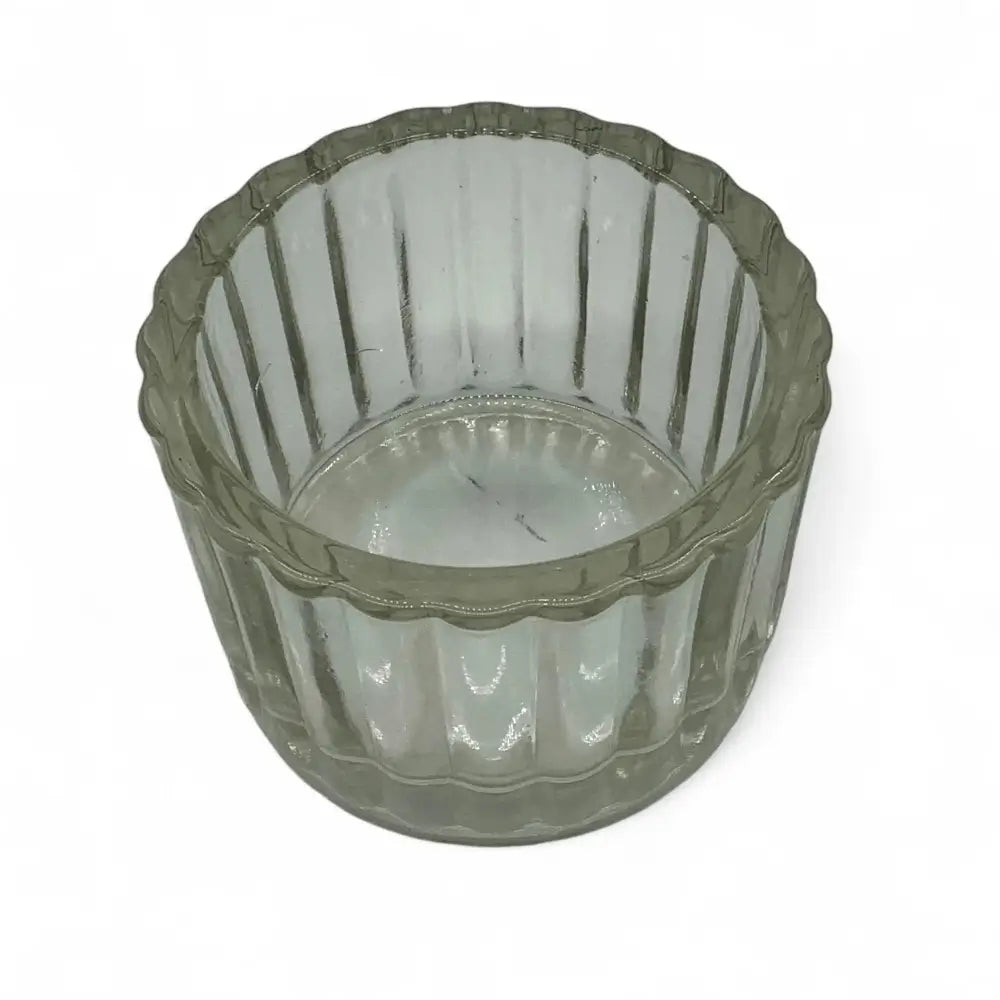 Clear glass candle holder with ribbed design on a white background