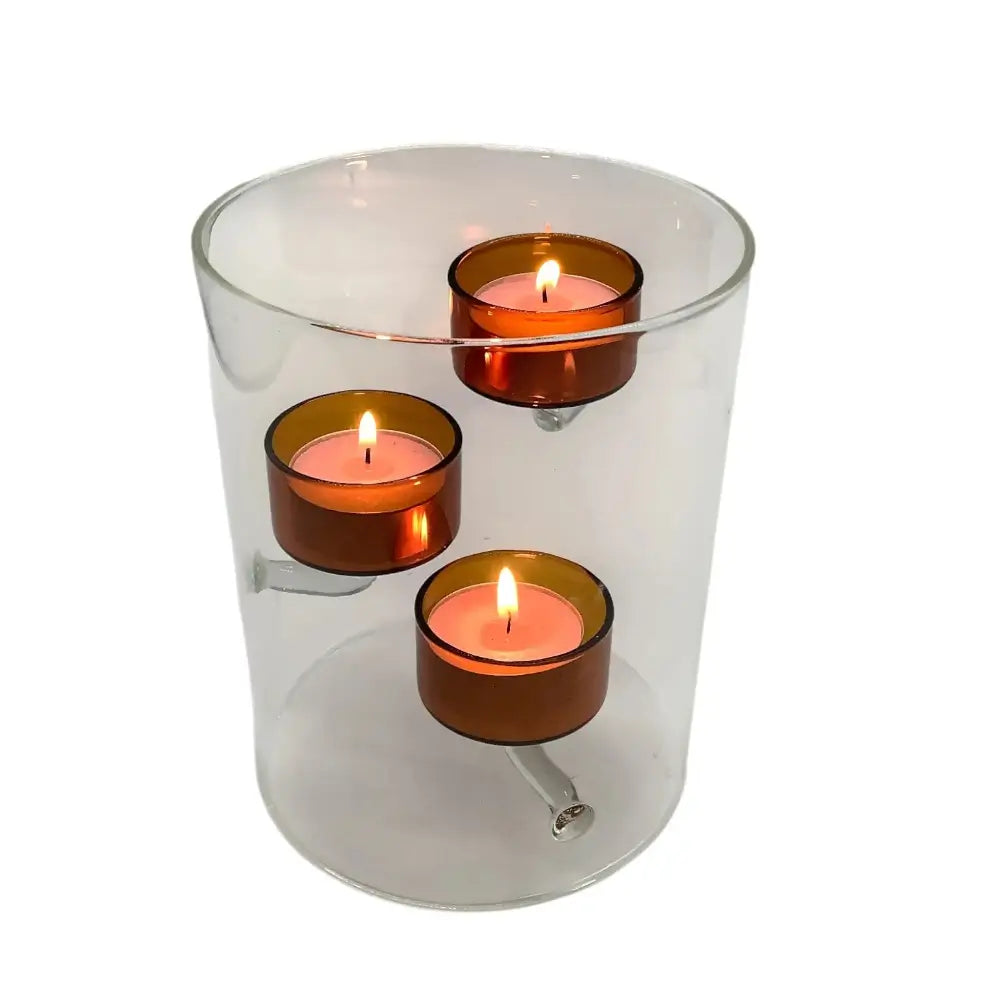 Clear glass holder with three orange candles on a white background
