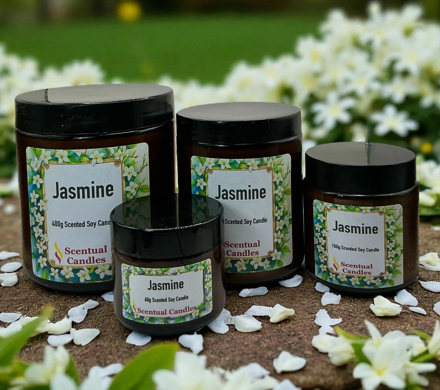 Jasmine scented candles with labels on a natural surface with flowers in the background