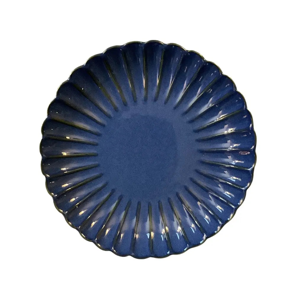 Blue decorative ceramic candle holder plate with a fan-like design on a white background