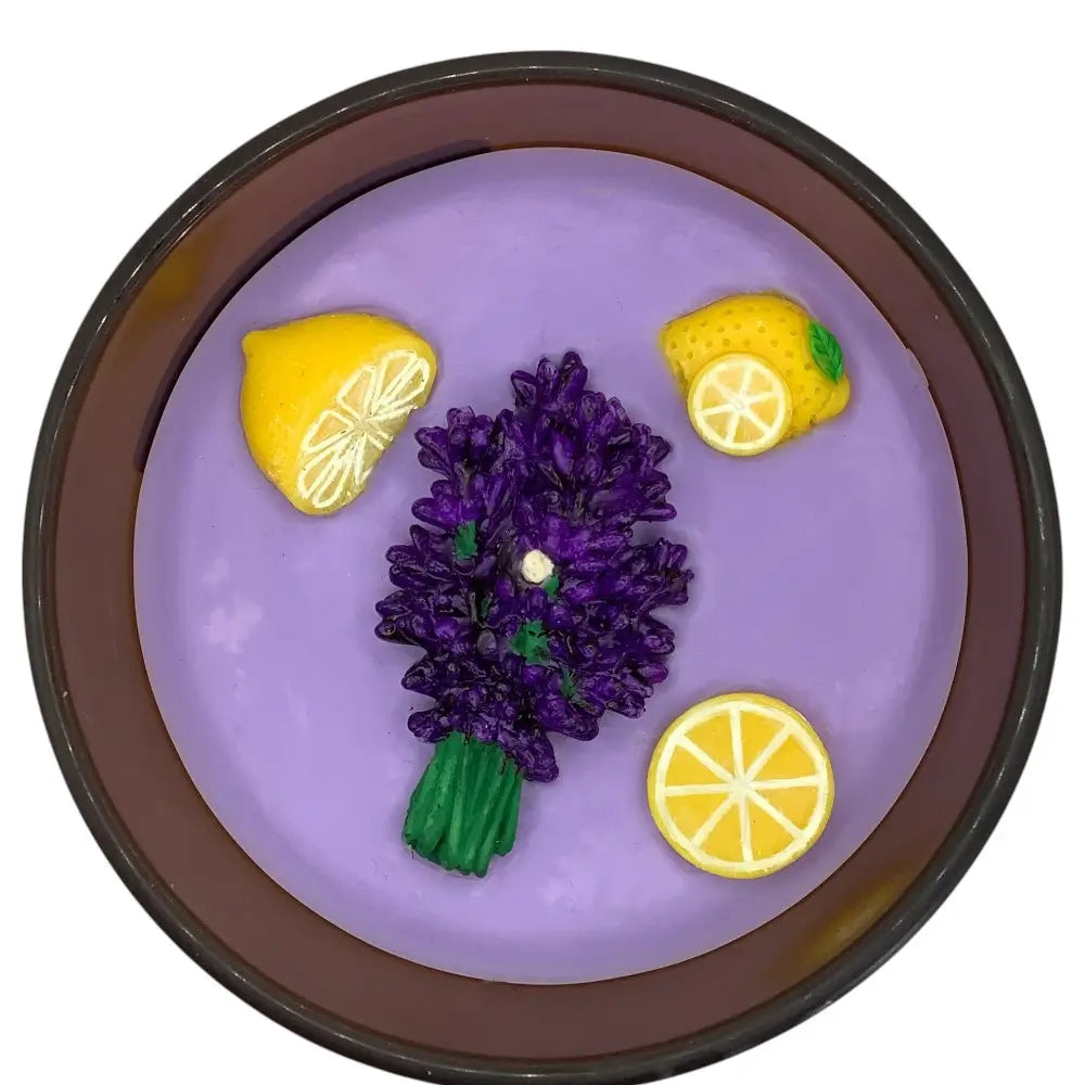 Purple candle with lavender and lemon decorations in a brown container
