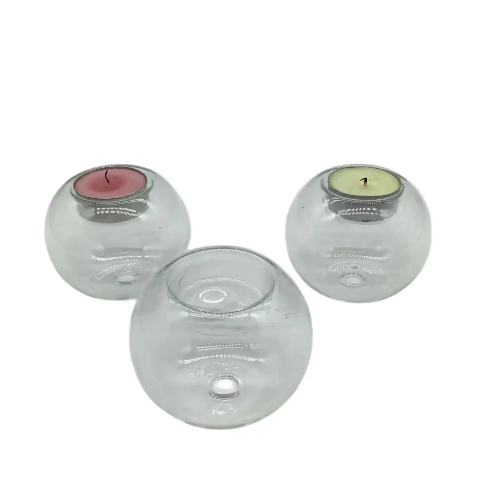 Three clear glass candle holders with embedded candles on a white background