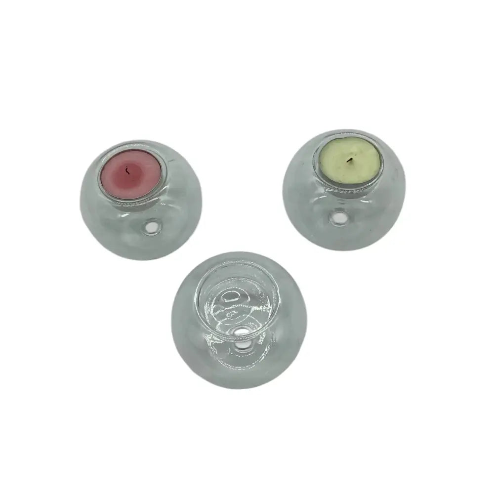 Three glass candle holders with candles inside on a white background