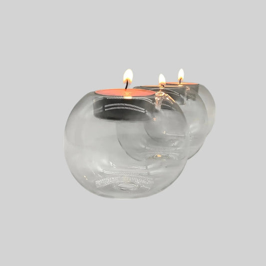 3 Orb glass candle holders with lit tealights in a row