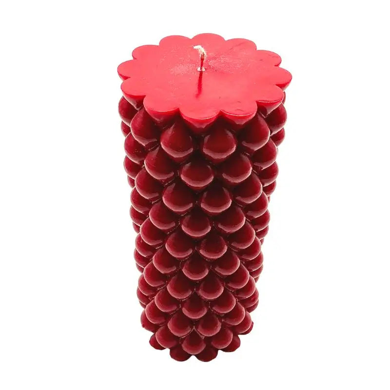 Red soy pillar candle with textured design, similar to Vanilla and Cinnamon scented candles for a cozy ambiance.