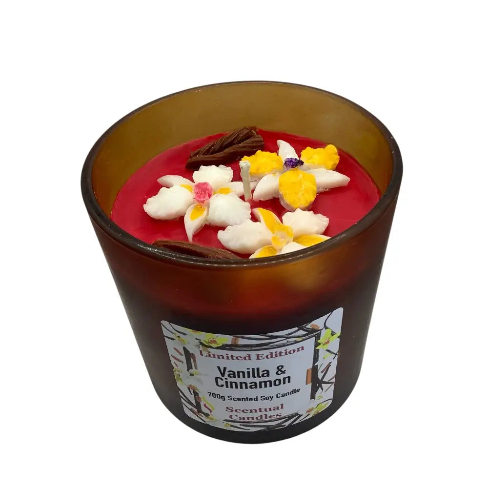 Vanilla & Cinnamon scented candle with floral decorations on a white background