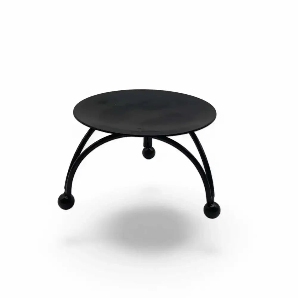Round black metal candle stand with three-legged geometric base and matte finish.
