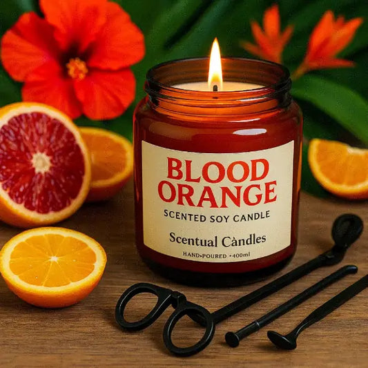 Blood Orange scented soy candle in a jar with oranges and flowers in the background