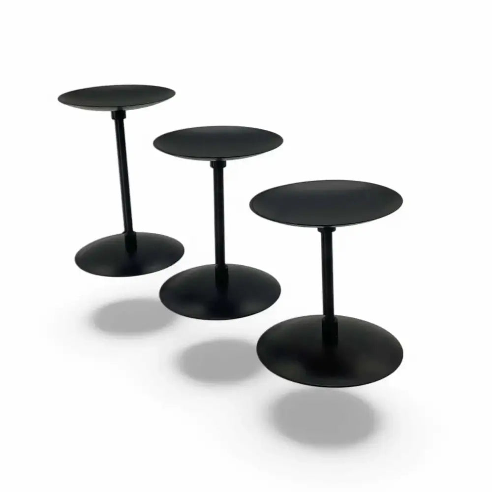 Three matte black wrought iron candle stands in varying heights, ideal for stylish home decor.
