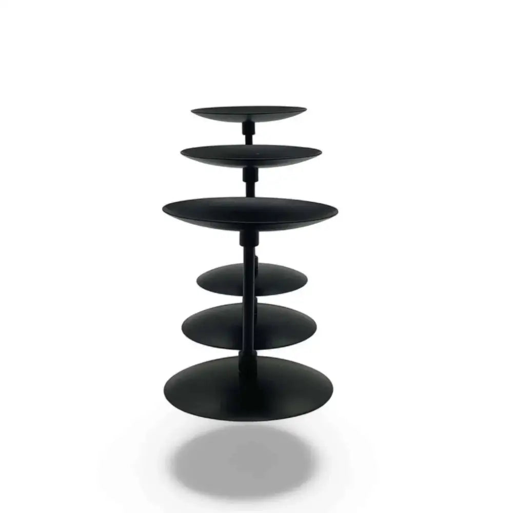 Three piece matte black wrought iron candle stands with varying heights and sleek design.
