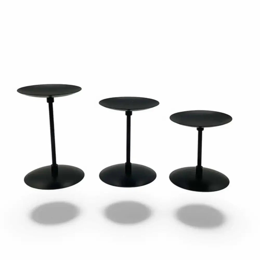 Three piece matte black wrought iron candle stands with varying heights, adding modern minimalist elegance to any decor.
