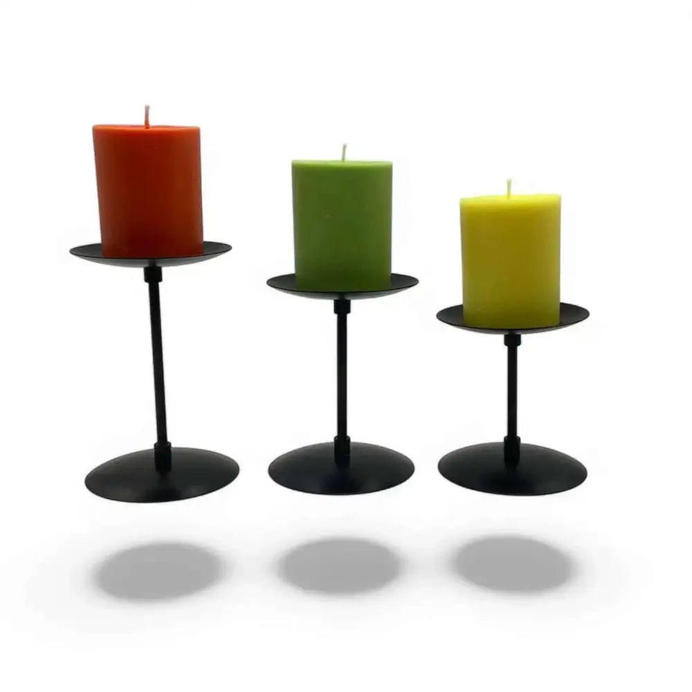 Three piece matte black wrought iron candle stands with colorful candles, featuring elegant trio design and heatproof construction.