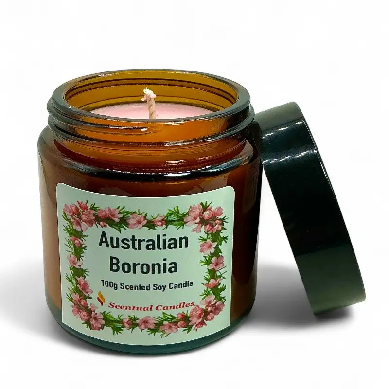 Scented soy candle in an amber jar with a floral label on a white background
