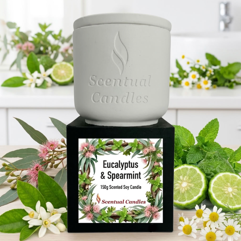 Australian Botanicals Eucalyptus Candle with Spearmint in a decorative pot surrounded by fresh eucalyptus and spearmint leaves.