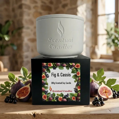 Fig Candle displayed in a stylish container with a black box labeled Fig & Cassis, surrounded by fresh figs and botanical elements.