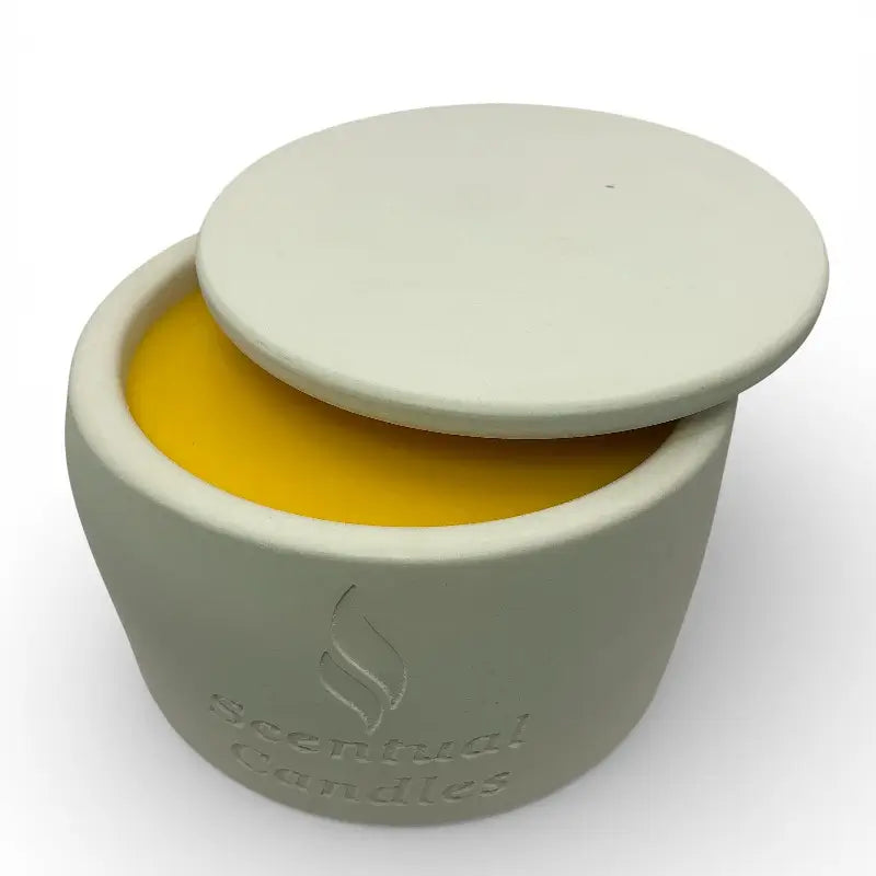 Jasmine candle in a jar with lid containing a yellow candle, branded 'Sensual Candles', on a white background