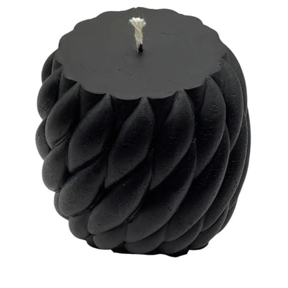 Black vanilla ball of yarn candle on white background