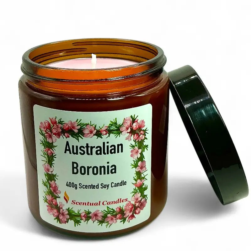 Scented soy candle in an amber jar with a floral label on a white background
