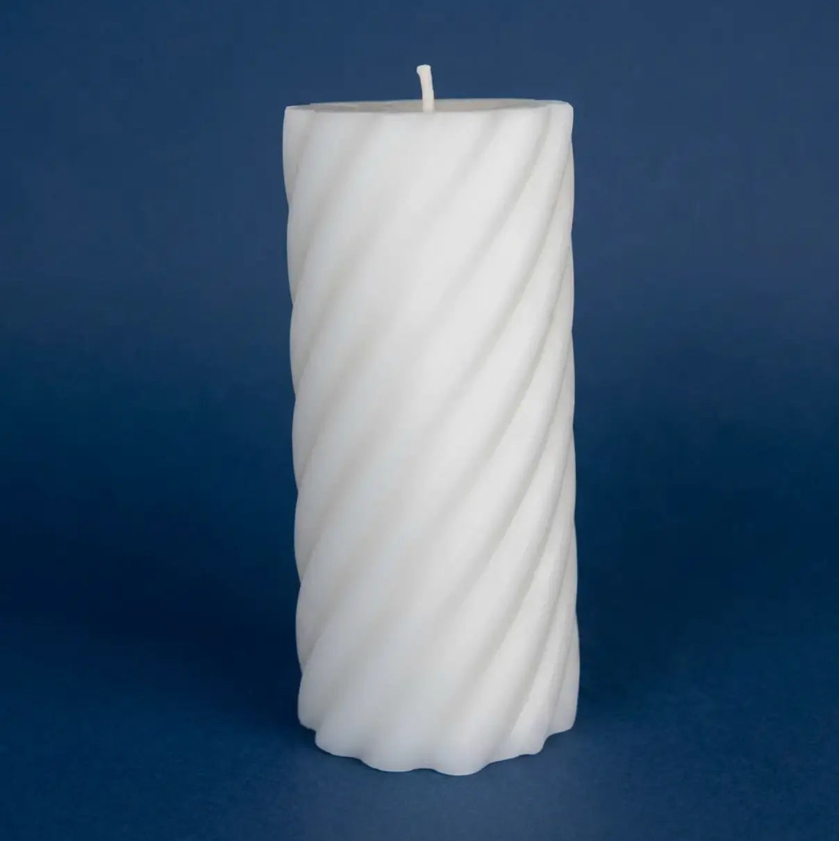 White Pillar Candles with coconut and lime scent on a blue background.