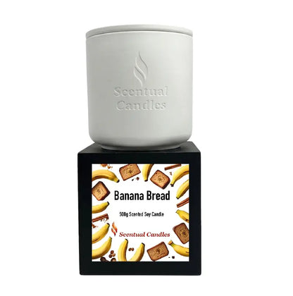 Banana Bread Candle in a sleek white container with a decorative box, featuring bananas and bread graphics.