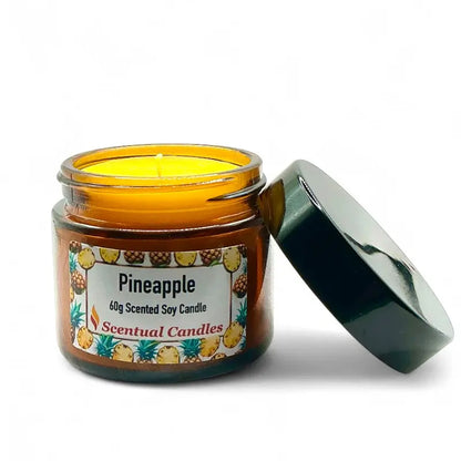 Pineapple Scented Tropical Soy Candle in amber jar with black lid, emitting fruity aroma for a tropical paradise feel.