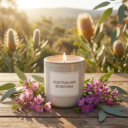 Scented Soy Candle with Australian Boronia flowers on wooden table outdoors