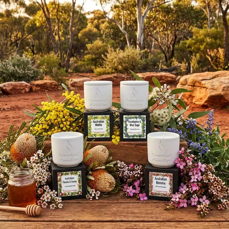 Australian Botanicals scented candle set. Four candles with natural elements on a wooden table outdoors