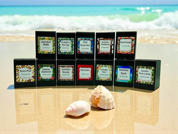 Australiana Candle Set featuring 12 Australian scents displayed on a sandy beach.