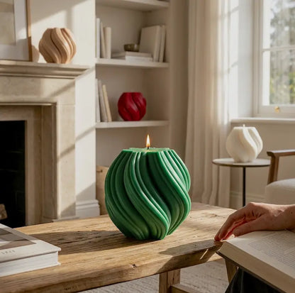 Ball Candle in green color lit on a wooden table, showcasing its unique sculptural design in a stylish living room.