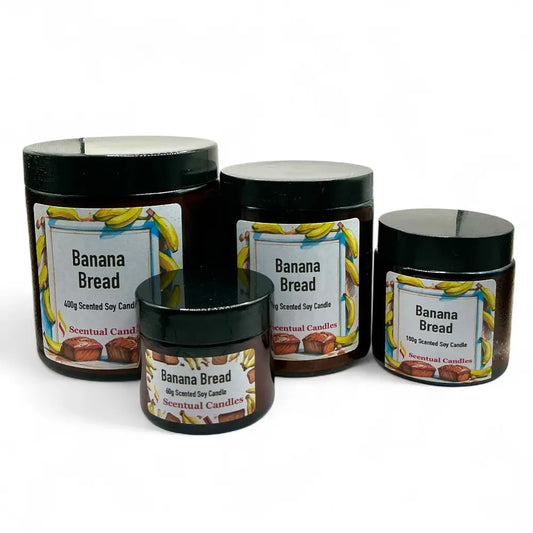 Four 'Banana Bread' scented candles of different sizes on a white background