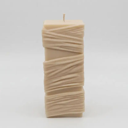 Beige Custom Candle in a large sculptural design with textured yellow wax and a single wick.