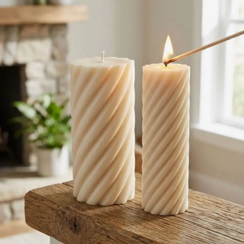 Pillar Candle Set featuring two spiral columns, one lit and placed on a rustic wooden table.