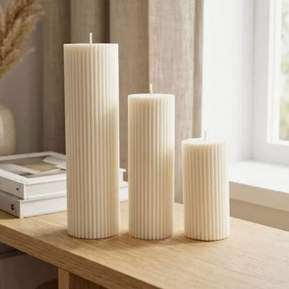 Ribbed Candles in a set of 3 pillar candles with varying heights and clean vertical ribbing, displayed on a wooden table.