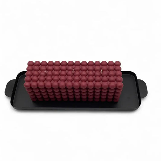 Red foam roller on a black tray with a white background